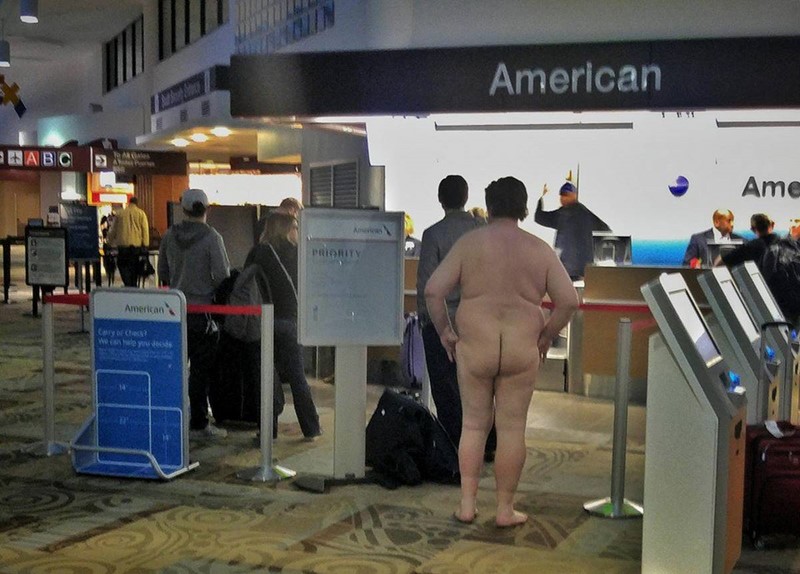 Un homme attend à un comptoir d'enregistrement totalement nu